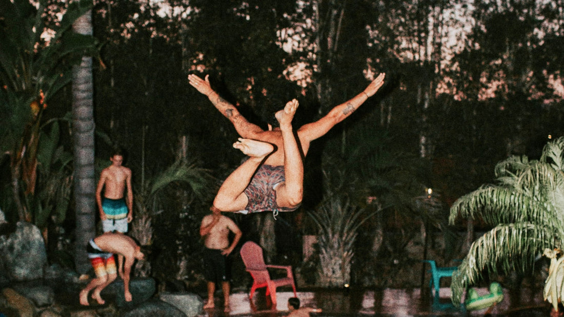 Man jumping into tropical swimming pool