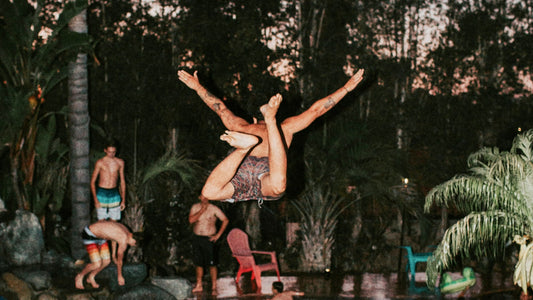 Man jumping into tropical swimming pool